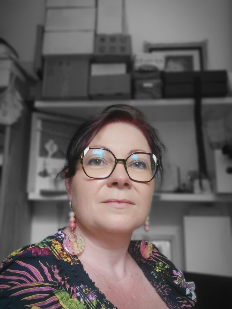 Portrait d'Anne Sophie, créatrice de la marque AnneFicelle , dans son atelier et portant une paire de boucles d'oreille en résine et fleurs d'Hydrangea Annabelle teinte aux couleurs de l'Arc en ciel.